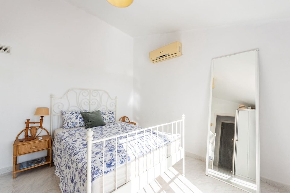 Dormitorio principal con cama de matrimonio, mesilla de noche y cuadro al fondo