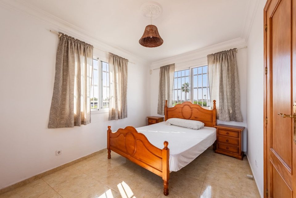 Dormitorio con cama individual de madera, mesilla y estantería