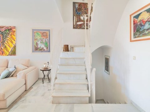 Salón del chalet — segunda vista con sofá, estanterías y acceso a la terraza
