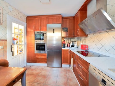 Cocina del chalet — mobiliario rojo, electrodomésticos de alta gama y vitrocerámica