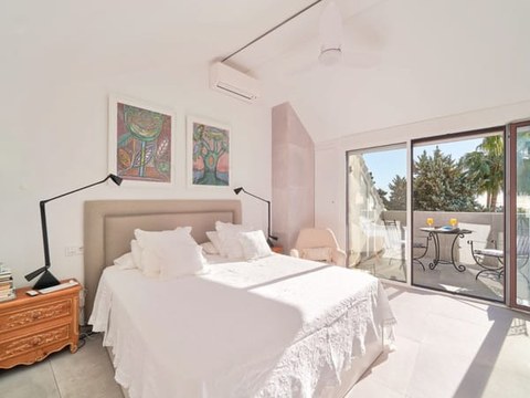 Dormitorio principal del chalet — cama de matrimonio, armarios empotrados y salida a terraza sur