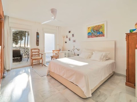 Dormitorio principal del chalet — segunda vista con butaca y balcón