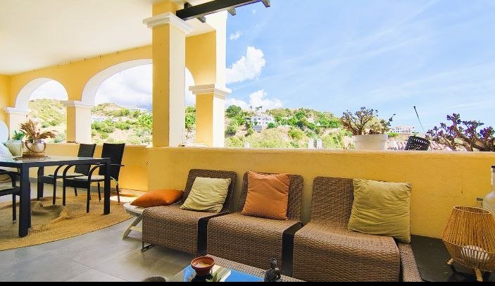 Terraza cubierta con arcos, sofás de rattan y vistas a la montaña — Arcos de La Quinta, Benahavís