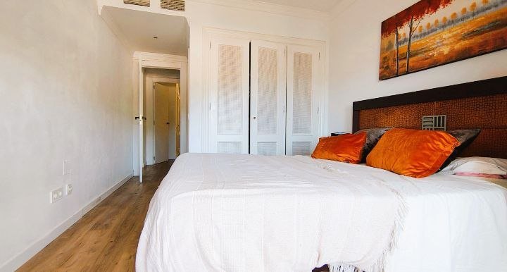 Dormitorio principal con cama doble y cabecero tapizado