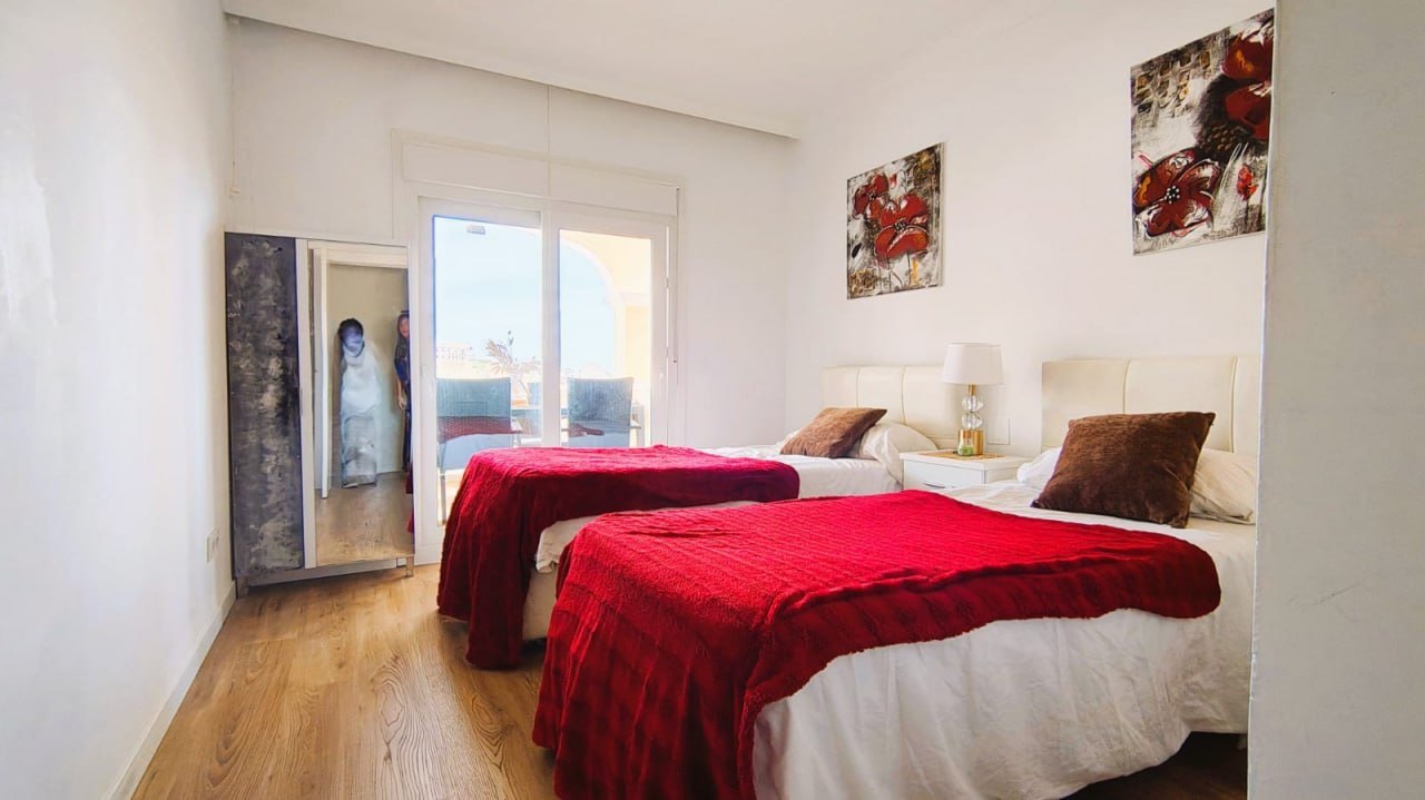 Dormitorio con colcha roja, reencuadre
